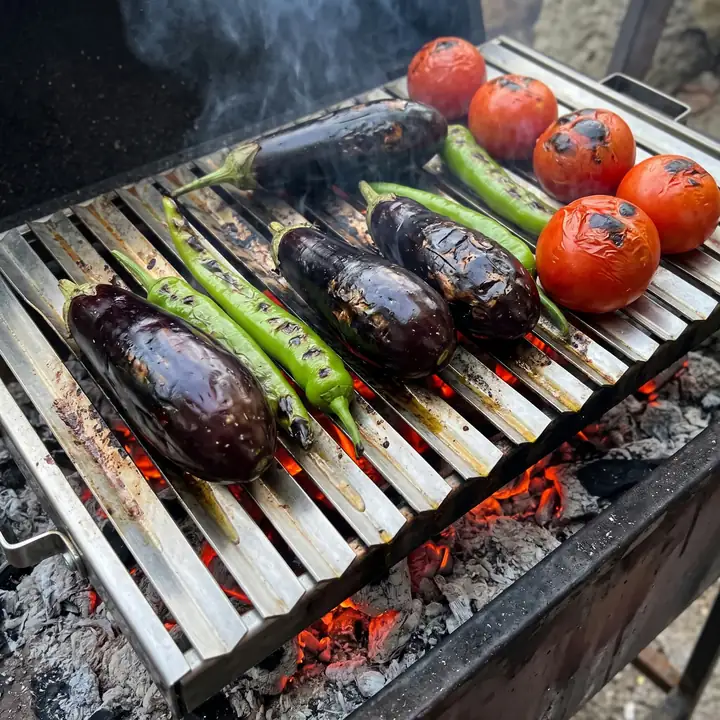Oluklu paslanmaz çelik ızgarada közlenen patlıcan, sivri biber ve domates